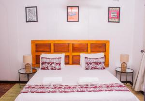 een slaapkamer met een groot bed en 2 tafels bij Casa Linda in Harare +6 foto's