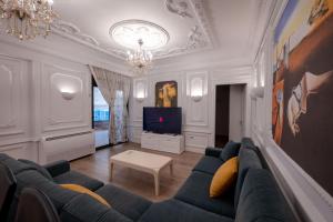 a living room with a blue couch and a tv at Luxury Apartment in Sarandë
