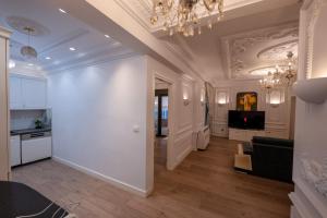 a large living room with a chandelier and a kitchen at Luxury Apartment in Sarandë