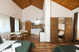 a room with two beds and a table and a kitchen at B&B Apartments Burić Plitvice Lakes in Plitvička Jezera