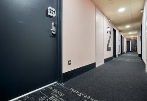 a hallway of an office building with a number on the wall at B&B HOTEL Ouistreham in Ouistreham