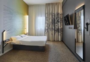 a hotel room with a bed and a window at B&B HOTEL Ouistreham in Ouistreham