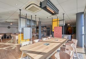 a conference room with a wooden table and chairs at B&B HOTEL Ouistreham in Ouistreham