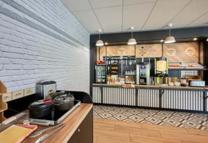 a restaurant with a counter and aasteryasteryasteryasteryasteryasteryasteryasteryastery at B&B HOTEL Ouistreham in Ouistreham