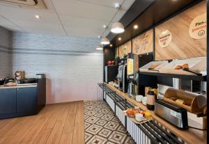 a fast food restaurant with a counter with food at B&B HOTEL Ouistreham in Ouistreham