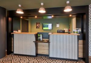 a fast food counter in a restaurant with lights at B&B HOTEL Ouistreham in Ouistreham
