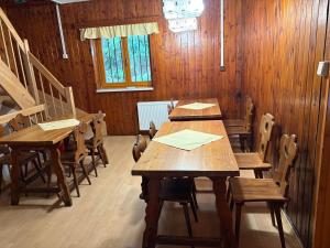 a group of wooden tables and chairs in a room at chata Zuzka in Železná Ruda