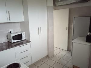 una piccola cucina con forno a microonde su un bancone di Stralenberg a Margate