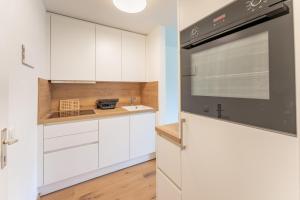 a kitchen with white cabinets and a stove top oven at Ferienwohnung Talblick in Raggal