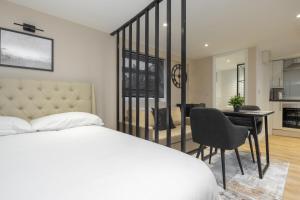 a bedroom with a bed and a desk and a kitchen at Luxury Studio Apartment in Stoke on Trent