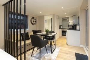 a kitchen and living room with a table and chairs at Luxury Studio Apartment in Stoke on Trent +11 photos