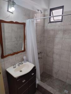 a bathroom with a sink and a shower with a mirror at Departamento céntrico in Concepción del Uruguay +6 photos