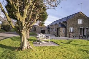 una panchina seduta di fronte a un edificio in pietra di The Horse Box a Leyburn