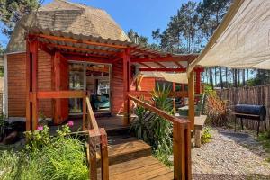 a tiny house with a deck and a gazebo at SAGRADAS de LA PALOMA in La Paloma
