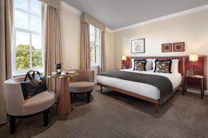 a hotel room with a bed and a chair at The May Fair, A Radisson Collection Hotel, Mayfair London in London