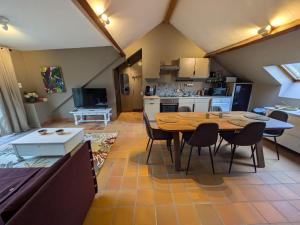 a kitchen and living room with a table and chairs at L'Air du Pré - loft 5p - Mariomont in Verviers