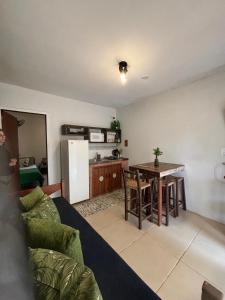 ein Wohnzimmer mit Couch und Tisch und eine Küche in der Unterkunft Pousada VistaCalma in Praia do Rosa