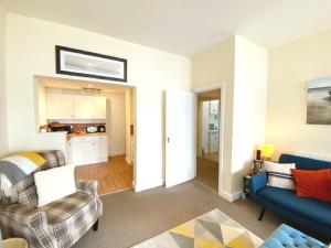 a living room with a couch and a chair at No1 Marina Court - Wow Sea View Apartment in Torquay