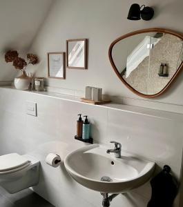 a white bathroom with a sink and a mirror at Apartment KURZ VOR BERLIN in Hoppegarten +37 photos