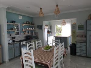 a kitchen with a table and chairs and a kitchen with a table and a table at Malibu Waters in Port Edward