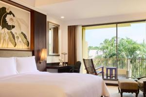 a bedroom with a bed and a balcony at Dusit Thani Pattaya in North Pattaya