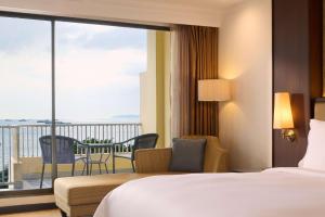 a hotel room with a bed and a balcony at Dusit Thani Pattaya in North Pattaya