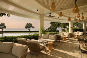 an outdoor patio with couches and tables and chairs at Dusit Thani Pattaya in Pattaya North