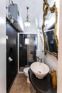 Un baño con lavabo, inodoro y espejo. en BigFamilyFlats - Coliseum Apartment, en Roma