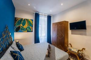 1 dormitorio con 1 cama con cortinas azules y TV en BigFamilyFlats - Coliseum Apartment, en Roma