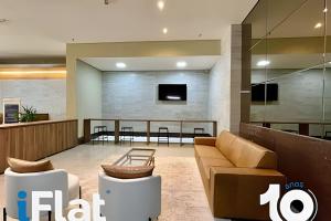 a lobby with a couch and a tv in a building at Espaço e Vista Brookfield Towers in Goiânia