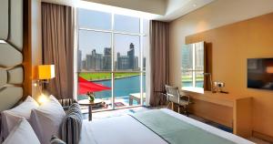 a hotel room with a bed and a large window at Canal Central Hotel Business Bay in Dubai