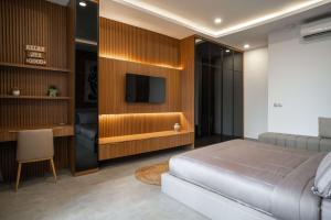 a bedroom with a bed and a flat screen tv at AZORA VILLAS - Bali Invest Club in Tumbak Bayuh