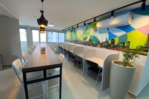 a dining room with white chairs and a colorful wall at iFlat brookfield Towers BTLX2817 Jardim Goiás in Goiânia