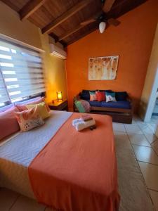 ein Schlafzimmer mit einem Bett und einer Couch in der Unterkunft Pousada VistaCalma in Praia do Rosa