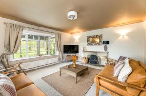 a living room with a couch and a fireplace at Central Malham Wellbeing Escape, 4-bed house with yoga studio in Malham