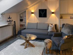 a living room with a couch and a table at Ferienwohnung Alpenglück mit Schwimmbad und Sauna in Oberstdorf
