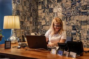 a woman sitting at a desk with a laptop computer at Villa Cascais Boutique Hotel in Cascais