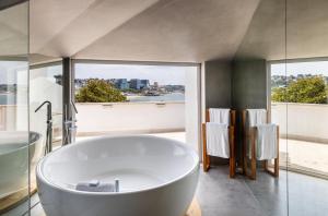 a large white tub in a bathroom with windows at Villa Cascais Boutique Hotel in Cascais +37 photos
