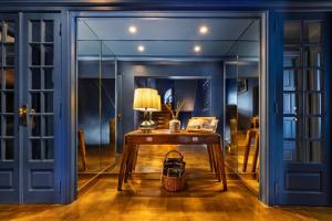 a blue room with a table and a lamp at Villa Cascais Boutique Hotel in Cascais