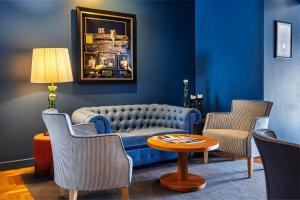 a living room with a blue couch and chairs at Villa Cascais Boutique Hotel in Cascais
