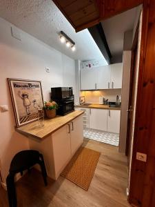 cocina con armarios blancos y mesa con microondas en Vistas a Pistas en Formigal Con Parking ATUAIRE HOME, en Formigal