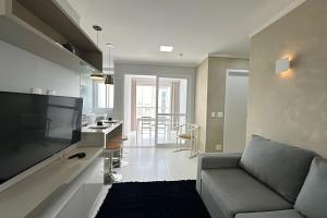 a living room with a couch and a kitchen at iFlat Metropolitan Barcelona MB1003B Jardim Goiás in Goiânia