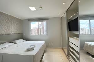 a bedroom with a large bed and a television at iFlat Metropolitan Barcelona MB1003B Jardim Goiás in Goiânia