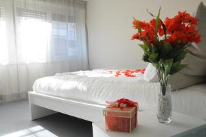 ein Schlafzimmer mit einem Bett mit einer Vase aus Blumen auf dem Tisch in der Unterkunft Alma Mater B&B in Rom