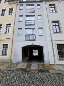 a large white building with a tunnel entrance at FERIENWOHNUNG 57m2 APARTMENT 2 RAUM MAISONETTEN WOHNUNG im ZITTAUER STADTZENTRUM INNENSTADT INNENRING TOP LAGE MARKT UND RATHAUS NÄHE in Zittau