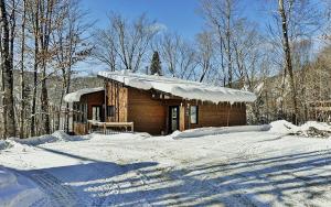 a log cabin with snow on the ground in front at 76.5 Chemin de la Perdrix in Stoneham