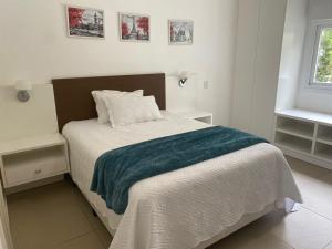 a bedroom with a bed with a blue blanket on it at Casa Condomínio Ocean Side Alto Padrão - Pé na Areia in Torres +43 photos