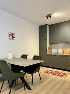 a dining room with a table and chairs and a kitchen at Kleon Apartament in Pristina