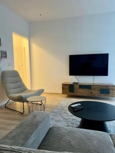 a living room with a tv and a couch and a table at Kleon Apartament in Pristina +16 photos