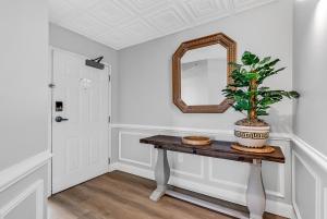 a hallway with a table with a mirror and a plant at 4BR Oceanfront Corner Condo NMB in Myrtle Beach +40 photos